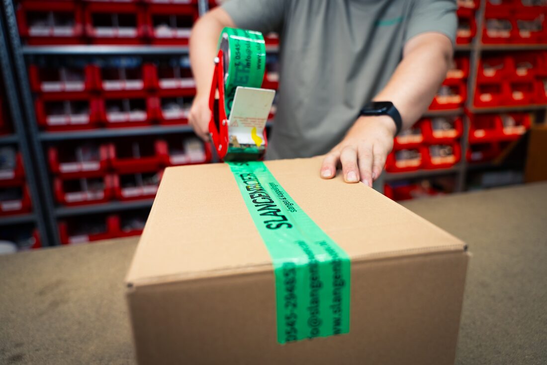 Bestelling wordt ingepakt met groene Slangenboer-tape